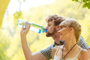 couple hikers resting in forest drinking water