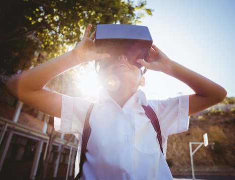 Boy in virtual reality glasses on campus