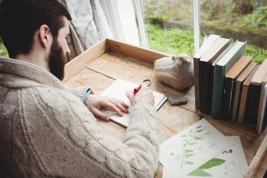 Attractive hipster man drawing at desk