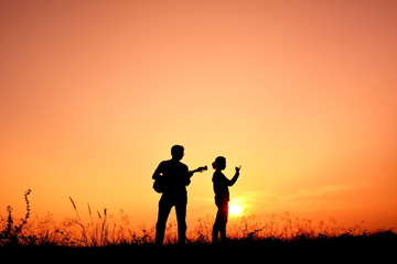 Fototapeta na wymiar Silhouette people playing musical at sky sunset