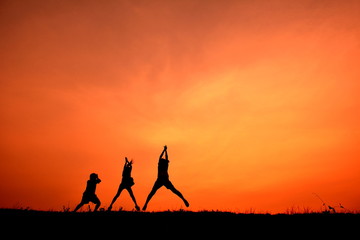 Silhouette women and children open hand in the sunset