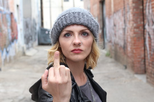Beautiful lady in leather jacket showing middle finger.