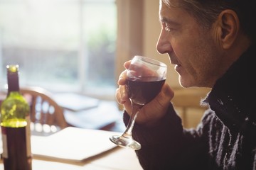 Profile view of man tasting red wine