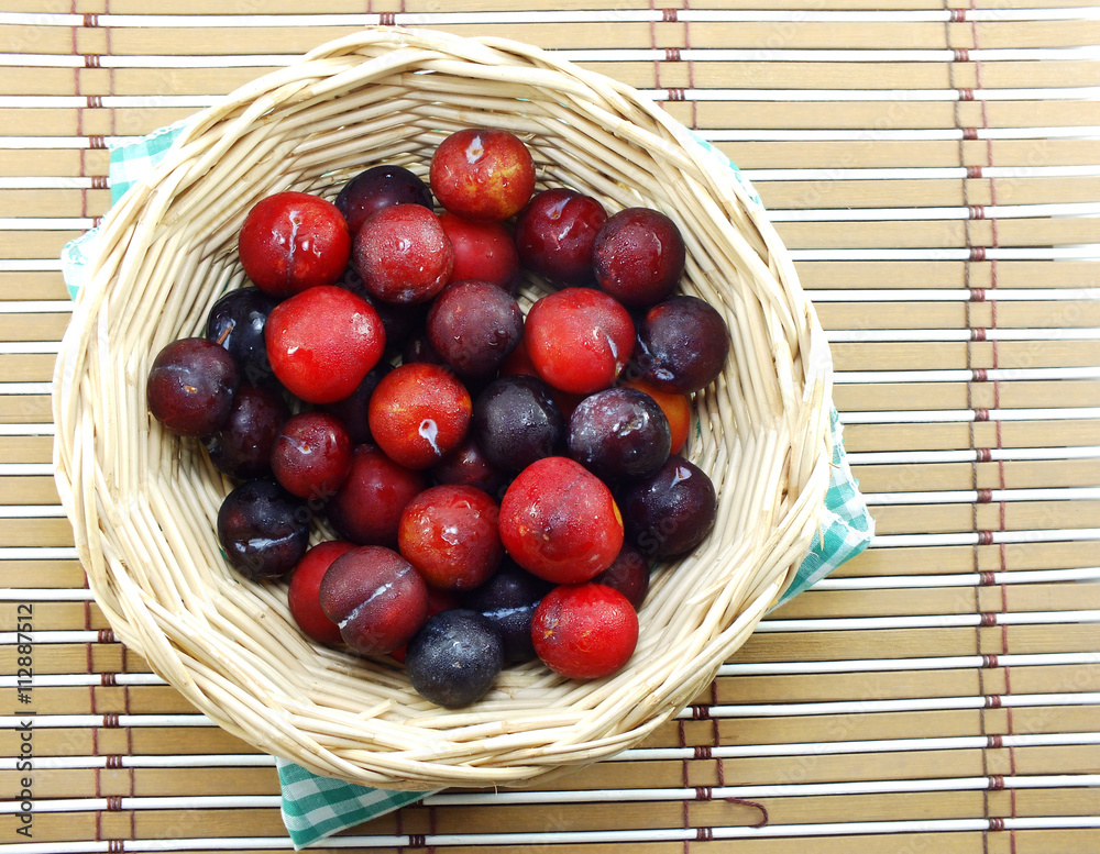 Wall mural red plum on wooden background top view