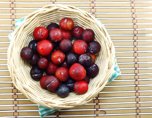 red plum on wooden background top view