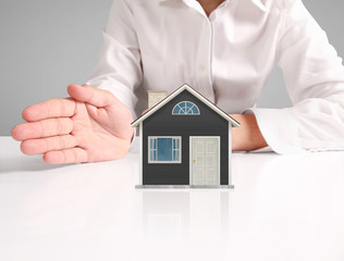 Mortgage concept by house from  hand