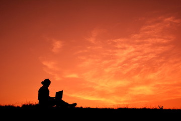 Fototapeta na wymiar Silhouette women using computer at sunset