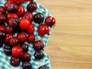 red plum on wooden background top view