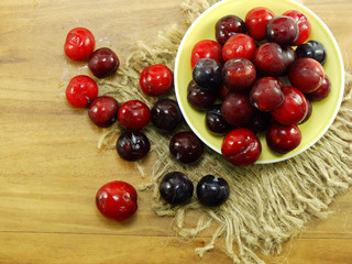 red plum on wooden background top view