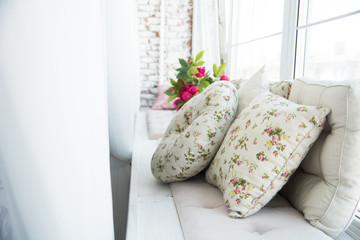 Pillows on the windowsill and plastic window