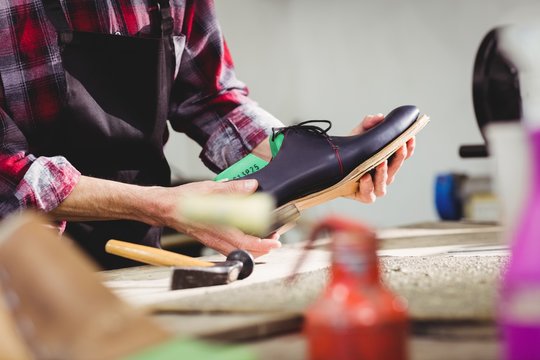 Close up of hands holding a shoe