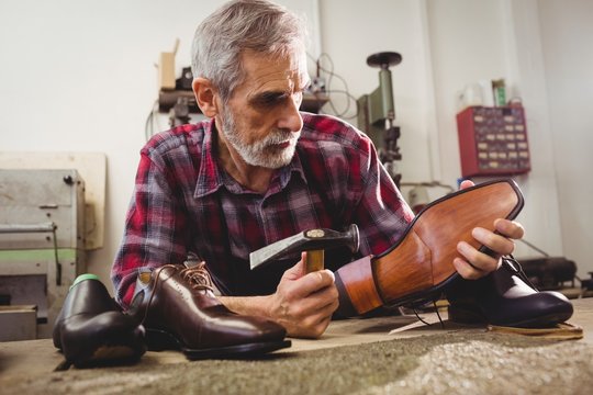 Cobbler hammering on the heel of a shoe