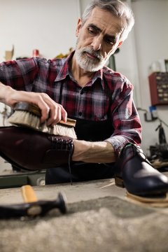 Portrait of cobbler polishing a shoe 