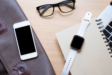 Business workplace from top smart watch, smart phone, glasses, laptop on wooden desk , retro style...