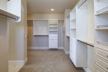 Large white walk-in closet with shelves.