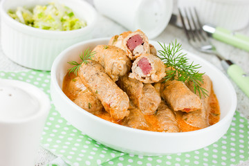 Meat fingers of pork fillet with ham stuffing in sauce