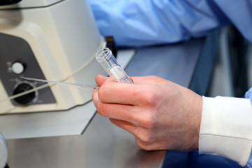 the technician holds in his hand an open test tube for medical 
