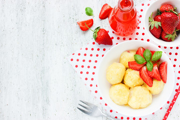 Cottage cheese dumplings with strawberries on white background