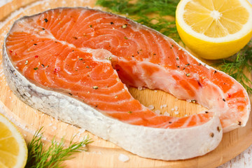 Raw salmon steak on wooden board