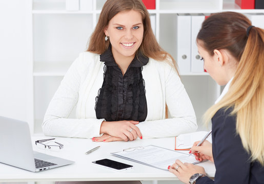 .Business, office, law and legal concept - picture of two woman signing contract paper.