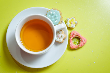 closeup of ginger cookies and cup of tea on light green background
