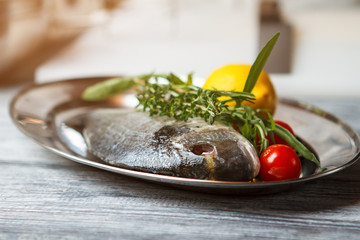 Raw fish with herbs. Plate with raw fish. Dorado fish and lemon. Simple recipe of seafood dish.