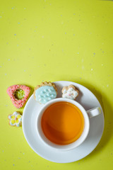 Ginger cookies and cup of tea on light green background
