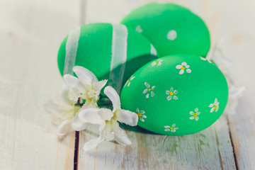 Easter eggs painted in pastel colors on white wooden background.