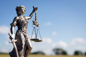 Obraz premium sculpture of themis, femida or justice goddess on bright blue sky copy space background