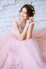 Fototapeta premium Bride in a tender light pink wedding dress in a morning. Fashion beauty portrait