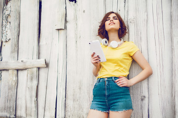 Fototapeta premium Funny Hipster Girl over white old wooden wall, hipster outfit Going Crazy at tropical island.Trendy Casual Fashion Outfit in summer,spring.Toned Photo,Copy Space.