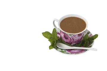 Isolated on white background Color cup of coffee on a saucer with a spoon, decorated with mint leaves.