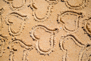 Group of many love heart symbols on sunny sandy beach background. Lovely holiday vacation greeting card.