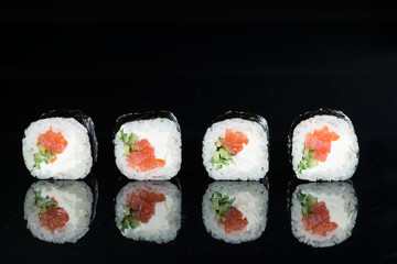 Obrazy na Szkle  zbliżenie sushi z łososiem i ogórkiem na ciemnym tle