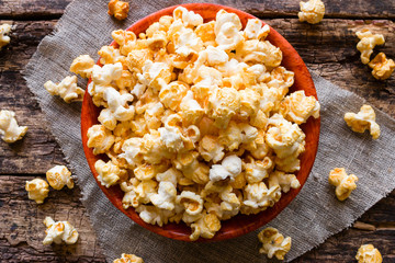 plate with popcorn on a napkin on a wooden background