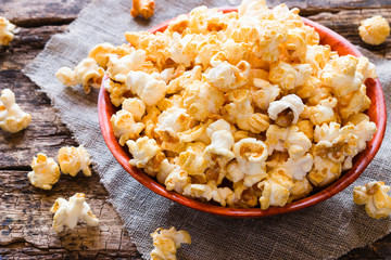 Popcorn in a bowl and scattered on a table close-up