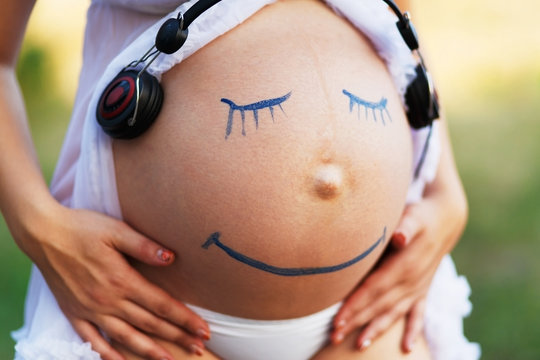 Pregnant woman belly closeup with smile funny face