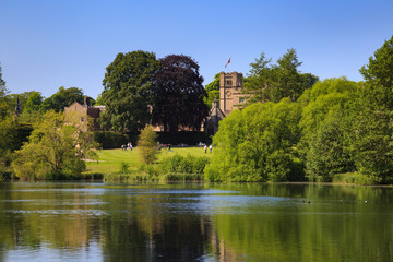 Fototapeta na wymiar NEWSTEAD ABBEY, JUNE 5: View of Newstead Abbey over the Garden Lake, visitors on the lawn. At Newstead Abbey, Nottinghamshire, England. On 5th June 2016.