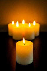 closeup to burning candles in darkness