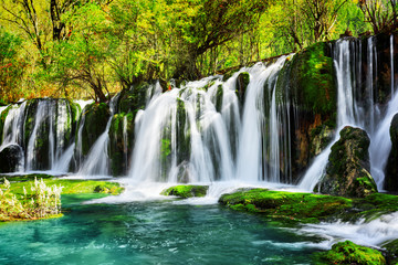 Amazing waterfall and azure lake with crystal clear water