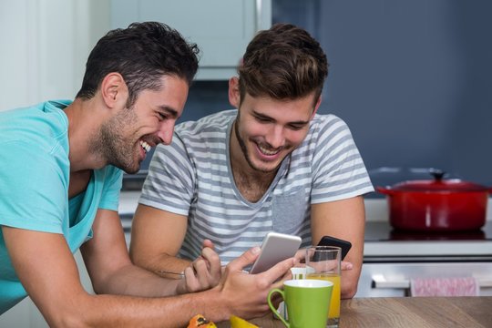 Cheerful Male Friends Using Phone 