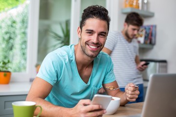 Portrait of smart cheerful man using phone
