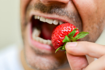 Man eating a strawberry