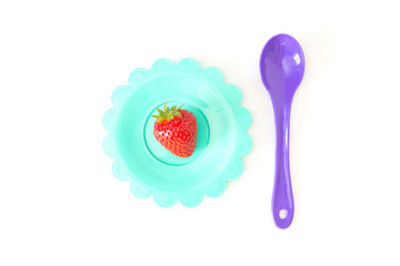 Strawberry on a bright saucer isolated white
