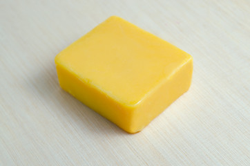 Mango natural extract soap bar isolated on wooden board backgrou