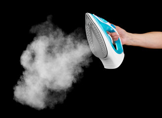 Steam iron in female hand isolated on black background.