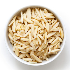 Bowl of peeled slivered almonds isolated on white from above.
