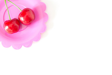 Obraz na płótnie Canvas Cherry on a bright saucer isolated white