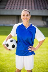 Portrait of female football player holding a ball