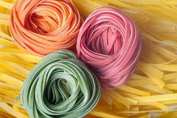 Three pieces of colorful raw italian pasta